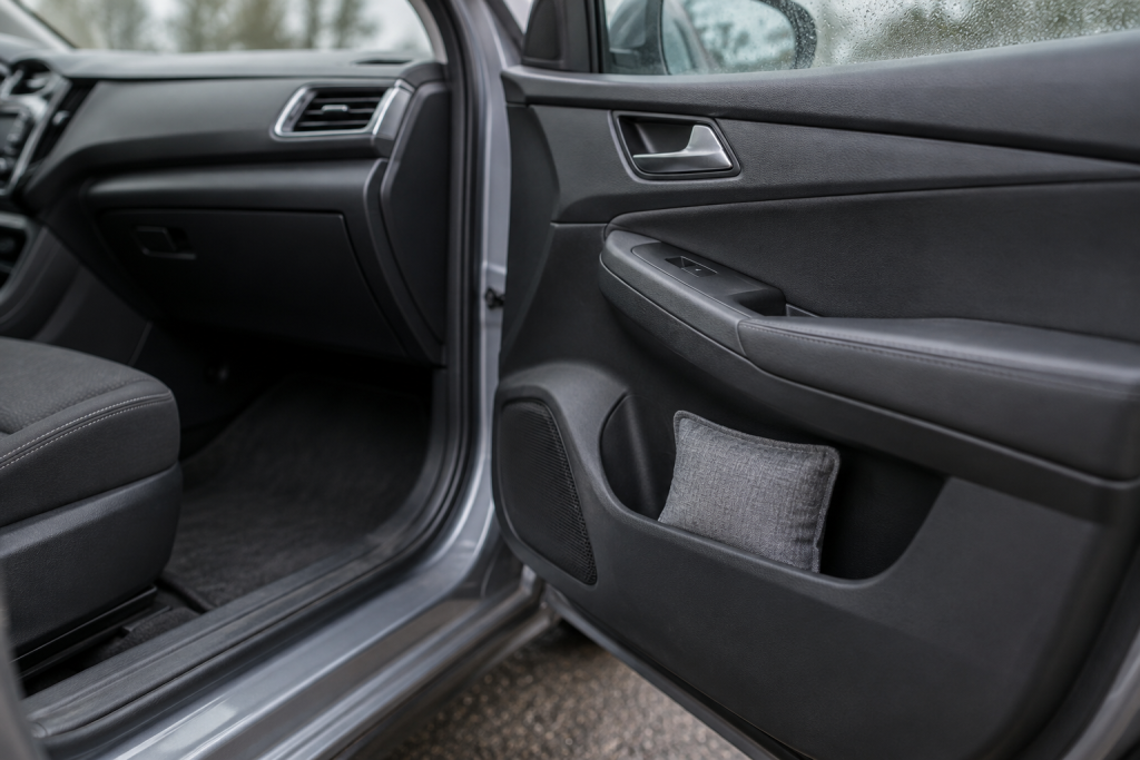 A plain reusable moisture absorber bag placed in a passenger door storage pocket